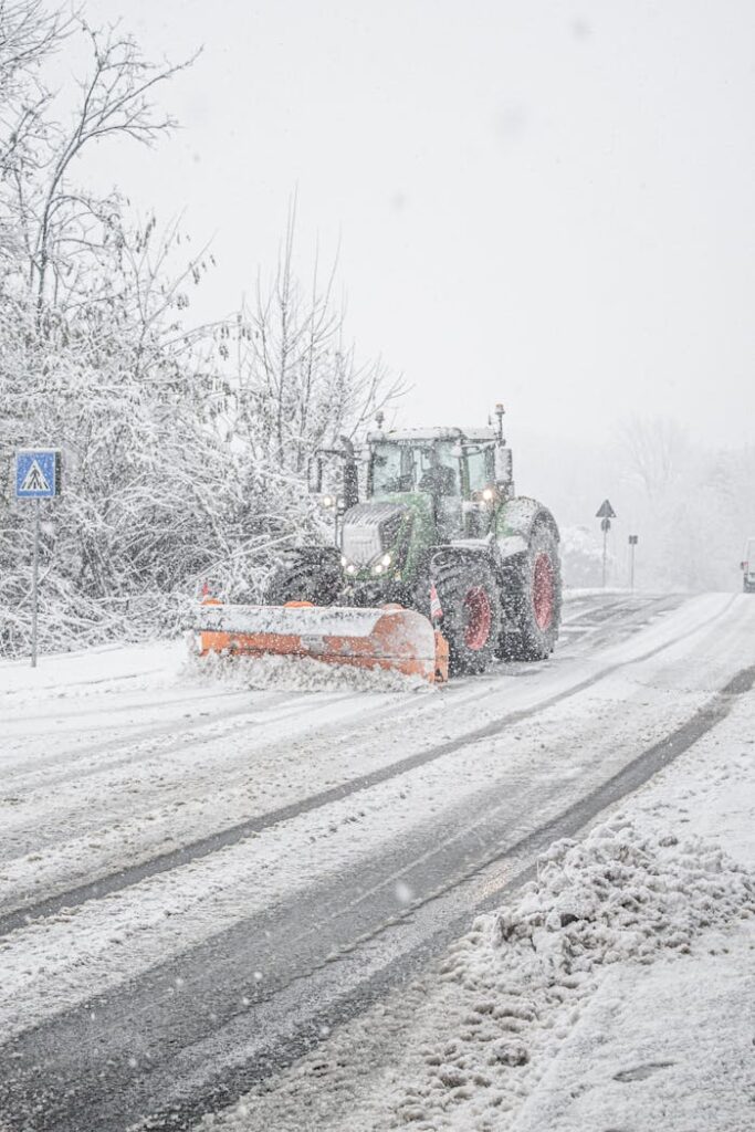 A snowplow clearing heavy winter snow from a road, I, ensuring safe transportation.