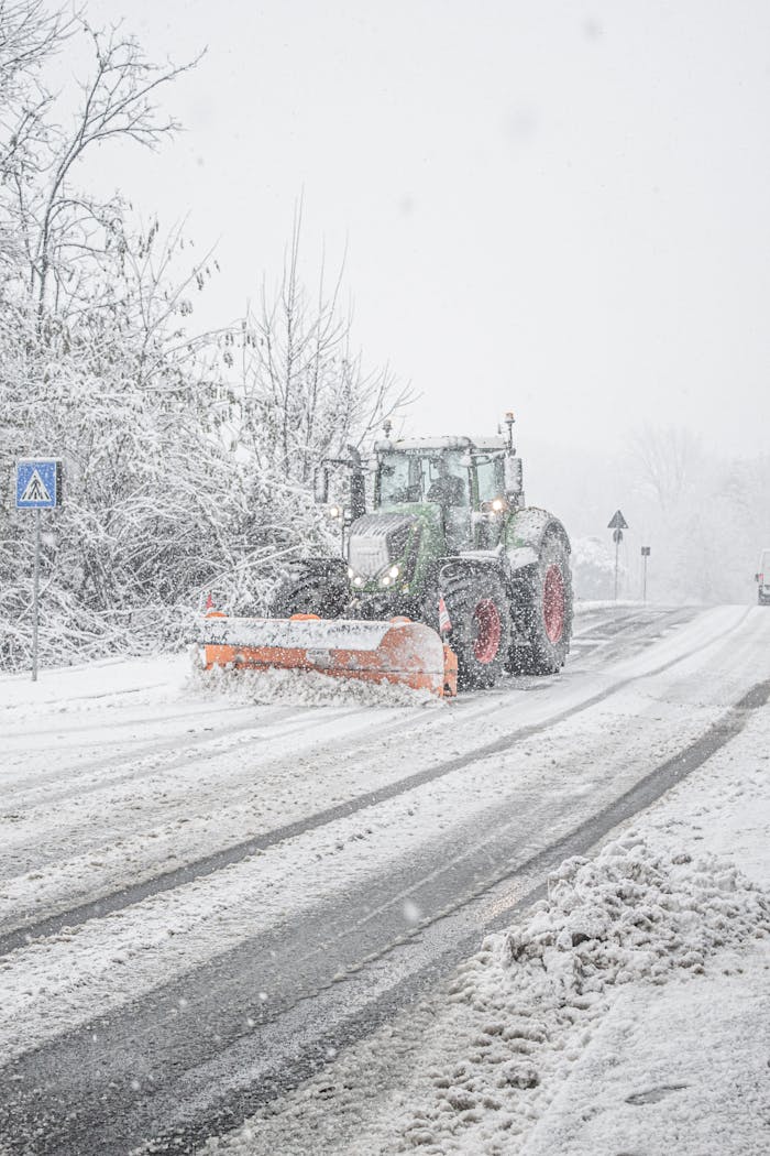 A snowplow clearing heavy winter snow from a road in Como, Italy, ensuring safe transportation.